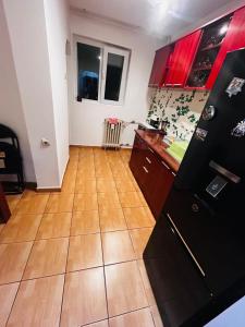 a kitchen with black cabinets and a wooden floor at Apartament CC in Drobeta-Turnu Severin