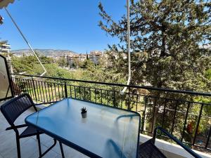 a table and chairs on a balcony with a view at Alimos Signature in Athens