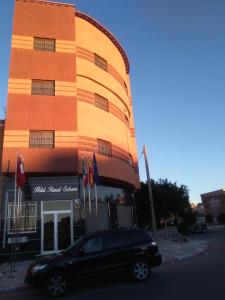 a black car parked in front of a building at Hotel Rimal Sahara in Laayoune