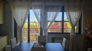 a dining room with a table and a large window at Appartamento Divino Tramonto in Altedo