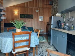 a kitchen with a table and a kitchen with a refrigerator at Studio aux portes de Parthenay in Châtillon-sur-Thouet +14 photos