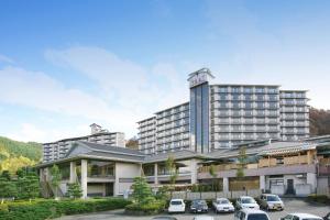 un grand hôtel avec des voitures garées dans un parking dans l'établissement Hotel Shion, à Morioka