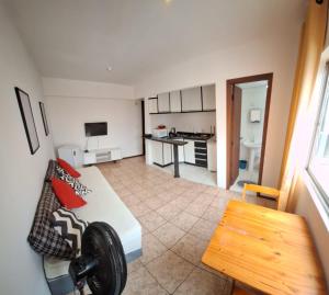 a living room with a couch and a kitchen at Loft central, cozinha e sala in Joinville