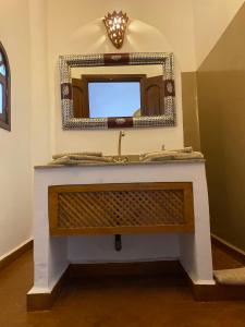 a bathroom sink with a mirror on a wall at Riad les trois merveilles in Essaouira