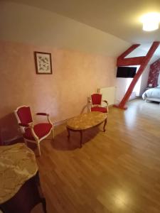 a room with a table and chairs and a bed at Les Castelblotines in Châteaubleau +1 photo