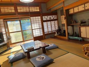 a living room with a table and some windows at 和の宿 禅 in Nachikatsuura