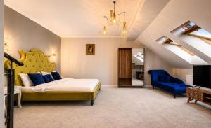 a bedroom with a large bed and a blue chair at Dallure House Boutique Brasov in Braşov