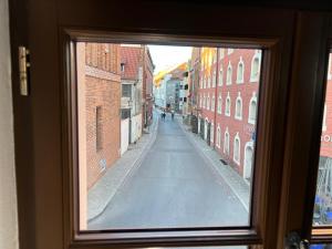 a view of a street through a window at ToRUŃ ApartHotel z widokiem na Wisłę i Krzywą Wieżę in Toruń