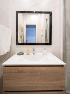 a bathroom with a sink and a mirror at appartement 15min de Paris in Drancy +26 photos