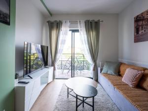 a living room with a couch and a table at appartement 15min de Paris in Drancy