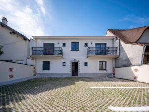 a white house with two balconies and a courtyard at appartement 15min de Paris in Drancy