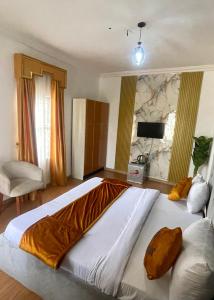 a bedroom with a large bed and a chair at Montevar Hotel in Benin City