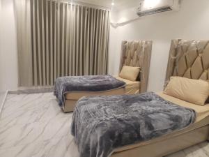 a room with two beds and a window at غرف عزاب وشقق عوايل in Riyadh +18 photos