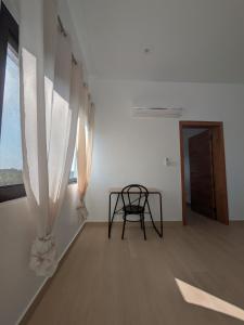 a chair sitting in a room with a window at Villa Hùéfa in Ouidah