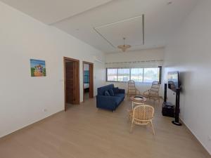 a living room with a blue couch and a table at Villa Hùéfa in Ouidah