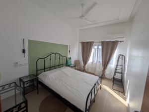 a bedroom with a bed and two windows at Villa Hùéfa in Ouidah +26 photos