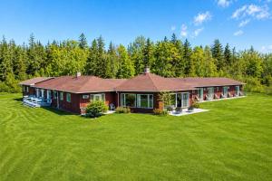a home with a large yard with a house at Baddeck Inn in Baddeck