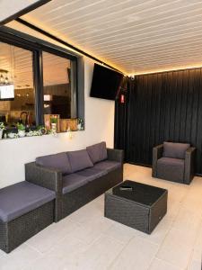 a living room with a couch and two chairs at BlueMaria in Eşelniţa