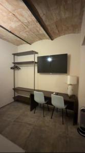 a room with two chairs and a desk and a tv at Alloggio del Trap in Ferentillo
