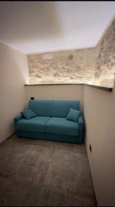 a blue couch in a room with a ceiling at Alloggio del Trap in Ferentillo