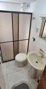 a bathroom with a toilet and a sink at Loft central, cozinha e sala in Joinville
