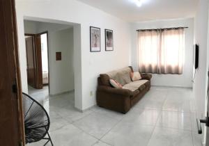 a living room with a couch and a television at Loft central, cozinha e sala in Joinville