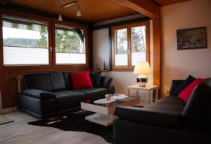 a living room with a couch and a table at Haus am Rotkreuzweg mit Pool in Feldberg +12 photos
