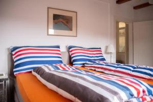 two beds with striped pillows in a bedroom at Haus am Rotkreuzweg mit Pool in Feldberg