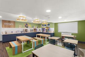 a classroom with tables and chairs and a whiteboard at Spark by Hilton in Beckley