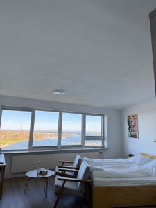 a bedroom with a bed and a table and windows at Inselblick 3 in Schleswig +7 photos