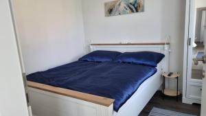 a bed with blue pillows in a white room at Ferienhaus zum Wunschglockerl in Schrems