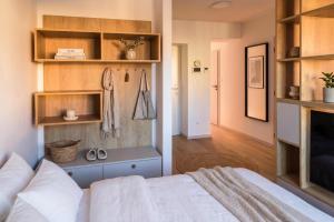 a bedroom with a white bed and wooden shelves at Villa Šanca in Bratislava