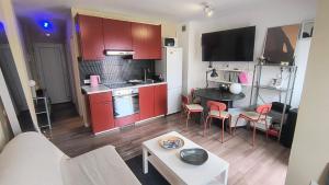 a small kitchen with red cabinets and a table at Casa Tropical in Costa de Antigua