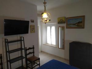 a room with a tv and a chair and a window at Casa delle Onde in Vada