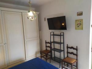 a bedroom with two chairs and a television on the wall at Casa delle Onde in Vada