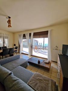a living room with a couch and a large window at Vista Mare Aegina in Kipséli