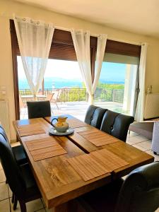 a dining room table with a view of the ocean at Vista Mare Aegina in Kipséli