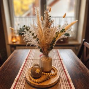 a vase on a table with feathers and nuts on it at Ferienwohnung Weber Alpenveilchen in Lechbruck +12 photos