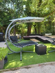 a swing with a table and an umbrella at Maison à la campagne in Tourves