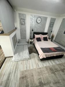 a bedroom with a bed and a clock on the wall at central studio LCS in Hunedoara