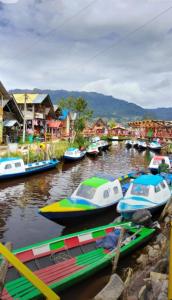 a group of boats docked in a river with houses at The Temple, Laguna de la Cocha in El Encano +26 photos