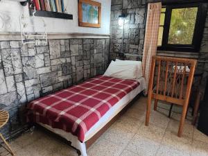 ein Bett in einem Zimmer mit einer Steinwand in der Unterkunft Casa Jazz in Salinas