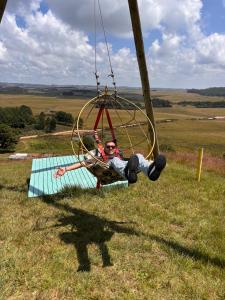 a man is swinging on a swing at Parador Pôr do Sol in Cambará