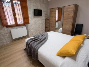 a bedroom with a large bed with yellow pillows at Costa Ovest Apartment 3 in Nurachi +9 photos