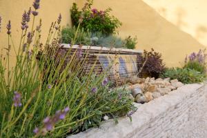 a garden with flowers and rocks in a stone wall at Costa Ovest Apartment 3 in Nurachi