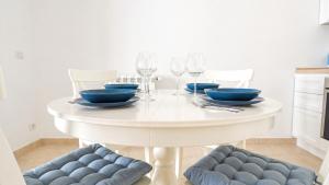 a white dining room table with blue dishes and wine glasses at Corte Nizza in Taviano