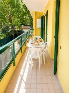 a balcony with a table and chairs on a balcony at Residence Pineta - Agenzia Cocal in Caorle