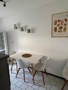 a white table and chairs in a kitchen at Rethmann Monteurwohnung Ferienwohung in Georgsmarienhütte