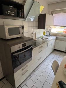 a kitchen with a microwave and a stove top oven at Rethmann Monteurwohnung Ferienwohung in Georgsmarienhütte