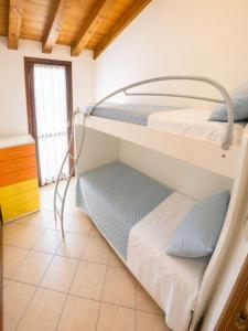 two bunk beds in a room with a window at Residence Pineta - Agenzia Cocal in Caorle